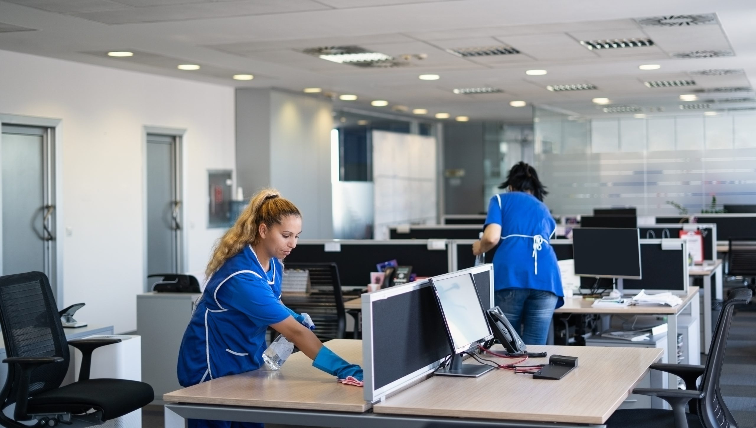 Deux femmes qui nettoient des bureaux.